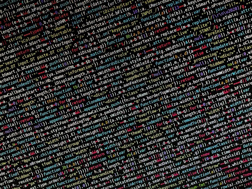 Close-up of a computer screen displaying a dense array of colorful programming code, with lines of HTML, JavaScript, and CSS visible. The code includes various tags, functions, and syntax highlighted